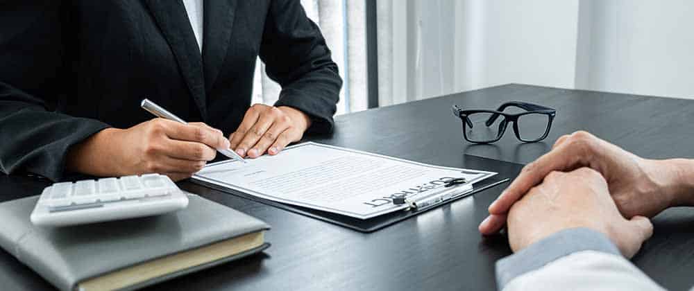 Professional consultation at desk with contract, calculator, and glasses, Water Pro services discussed by business experts.